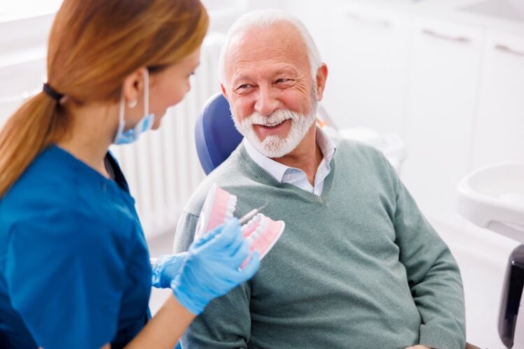 Dentist explaining procedure to patient on plastic jaw model